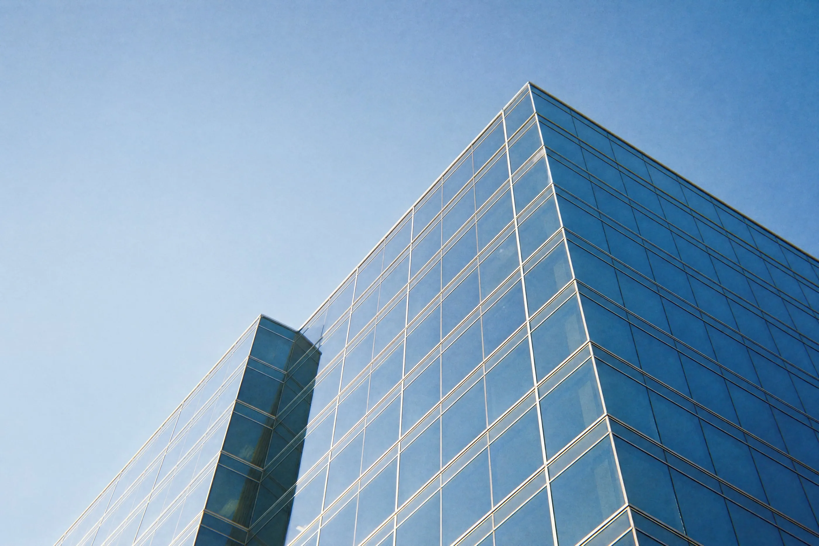 Fachada de cristal de un edificio de oficinas contra el cielo azul